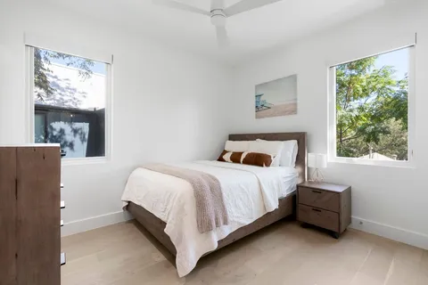 a bed sitting in a bedroom next to a window