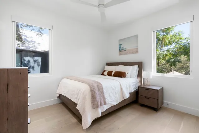 a bed sitting in a bedroom next to a window