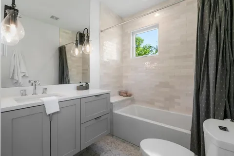 a bathroom with a granite countertop sink toilet and bathtub