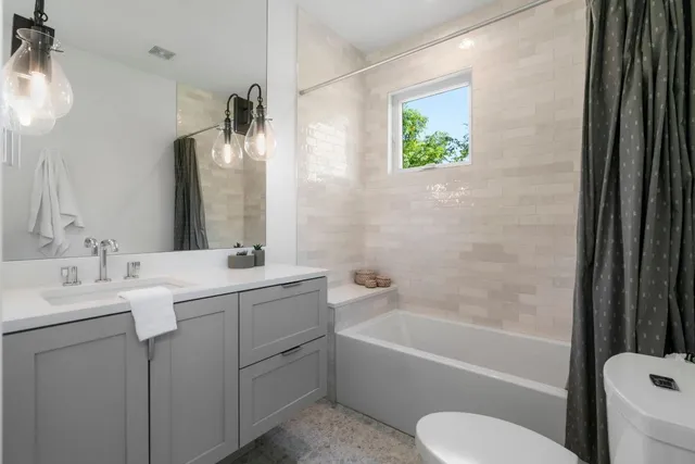 a bathroom with a granite countertop sink toilet and bathtub