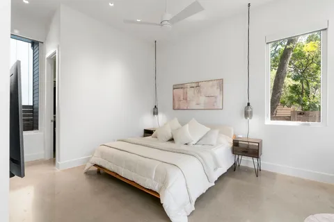 a bedroom with a bed lamps and a large mirror