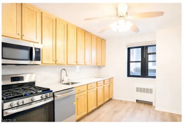 a kitchen with stainless steel appliances a stove microwave and sink