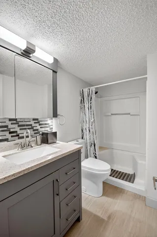 a bathroom with a double vanity sink toilet and shower