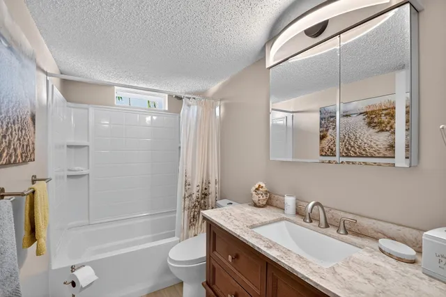a bathroom with a granite countertop sink toilet and shower