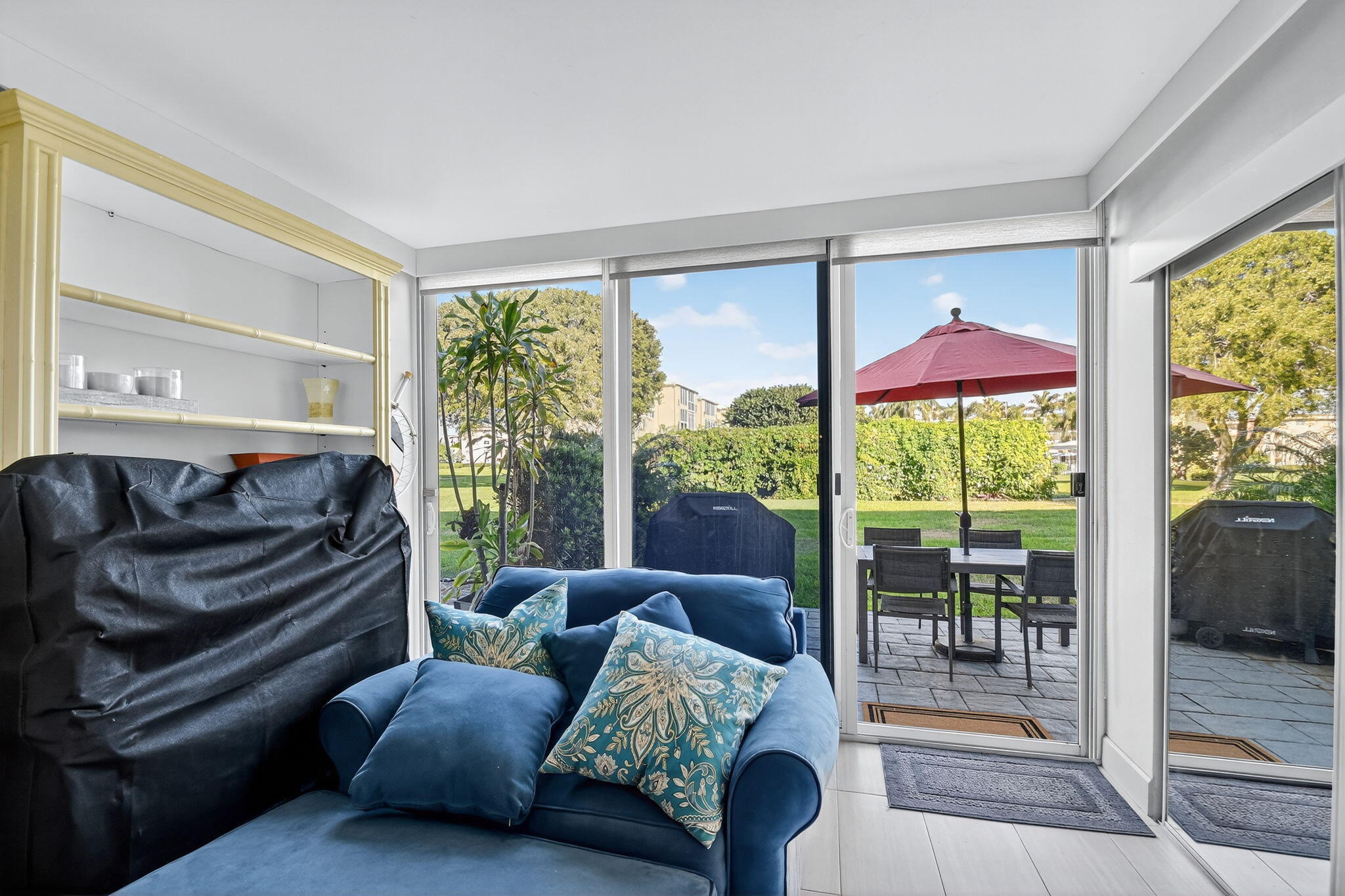 2400 Northeast 1st Lane, Unit 102 Boynton Beach, FL 33435 - Photo 27 of 44 a living room with furniture a floor to ceiling window and a flat screen tv