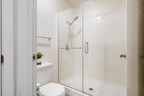 a white toilet next to a bathroom