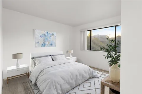 a bedroom with a bed and a painting on the wall