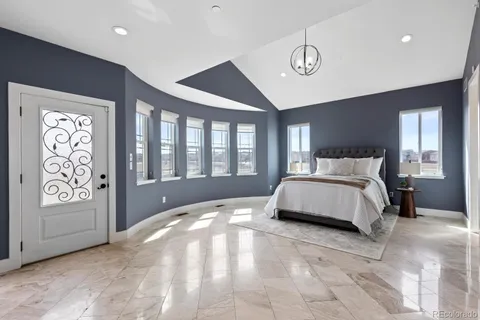 a spacious bedroom with a large bed and a chandelier