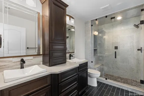 a bathroom with a double vanity sink toilet and shower