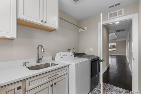 a utility room with sink dryer and washer