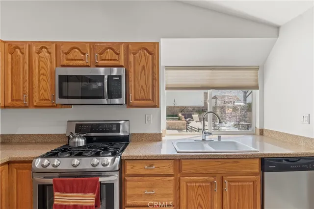 a kitchen with stainless steel appliances granite countertop a sink stove and microwave