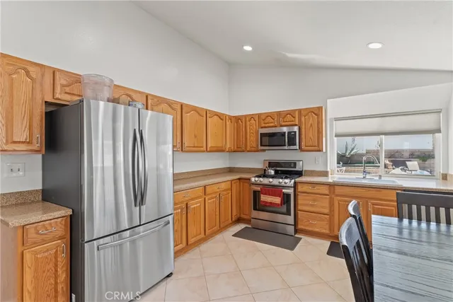 a kitchen with stainless steel appliances granite countertop a refrigerator sink and stove