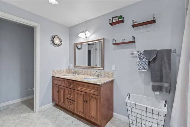 a bathroom with a granite countertop sink a mirror and a shower