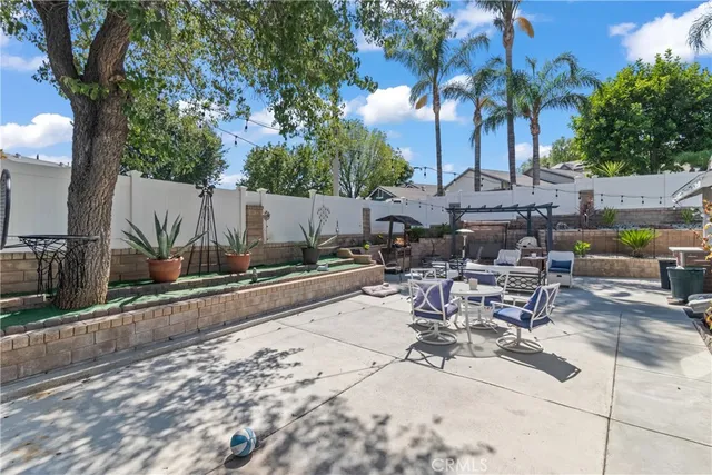 a view of a patio with table and chairs potted plants and palm tree