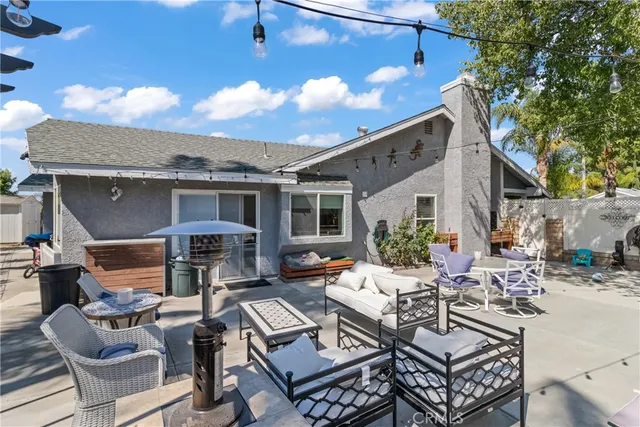 a view of a patio with couches and table and chairs with wooden floor and fence