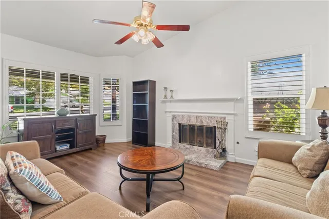a living room with furniture a fireplace and a large window