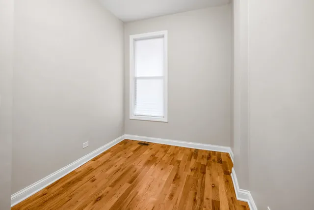 a view of small space with wooden floor and a window