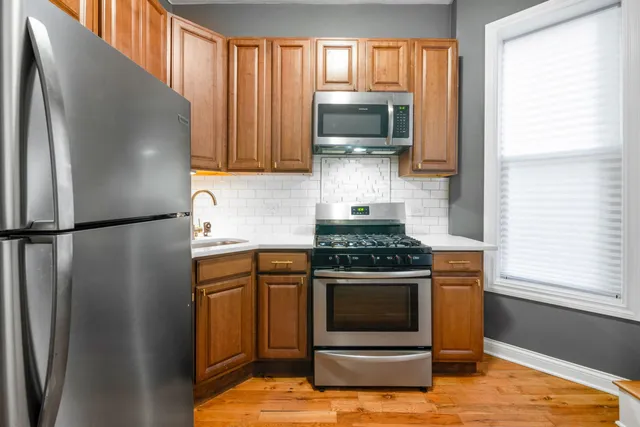 a kitchen with stainless steel appliances granite countertop a refrigerator stove and microwave