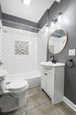 a bathroom with a toilet a sink a mirror a bathtub and shower