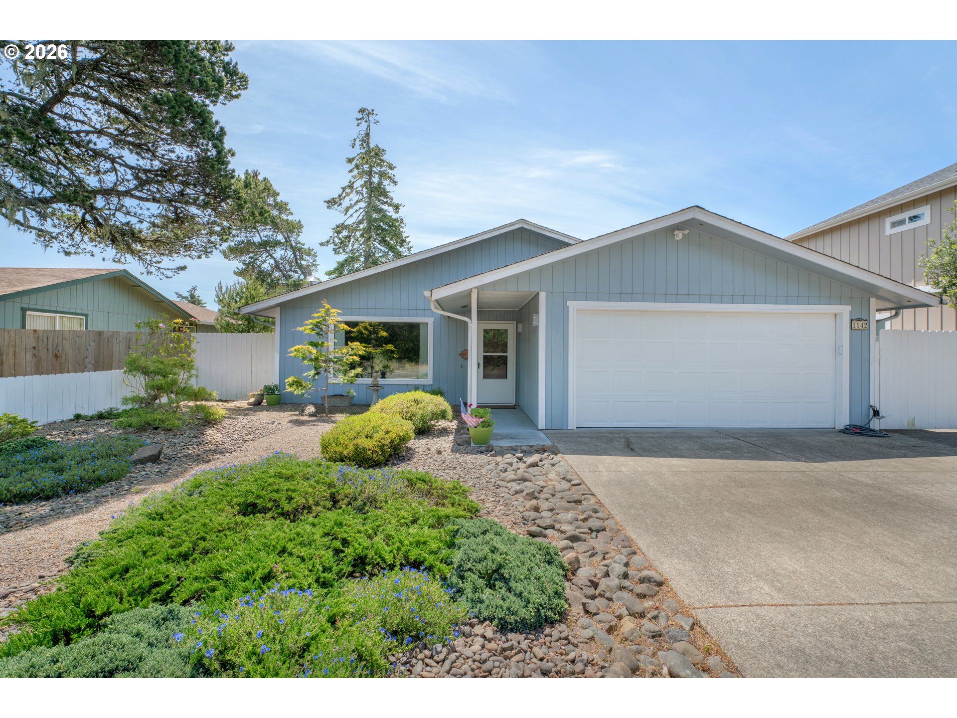 1142 9th Street Florence, OR 97439 - Photo 2 of 41 a front view of a house with garden