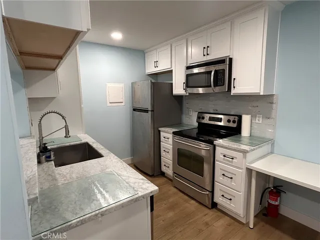 a kitchen with stainless steel appliances a stove microwave and a sink