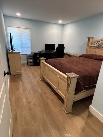 a spacious bedroom with a bed and chair