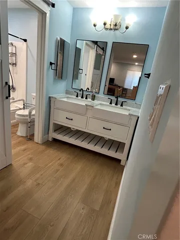 a bathroom with a double vanity sink mirror and toilet