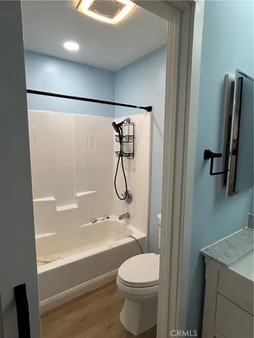 a bathroom with a granite countertop sink a toilet and shower