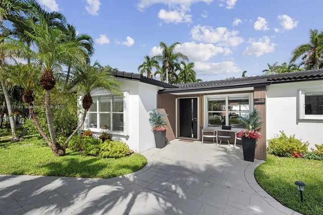 a front view of a house with a garden and outdoor seating