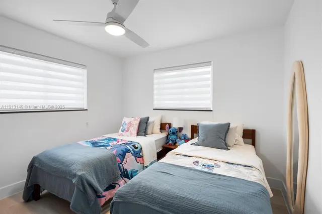a bedroom with two beds and a window