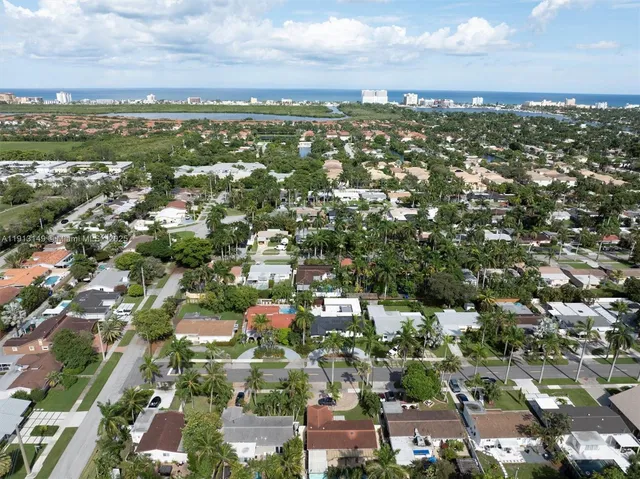 an aerial view of residential houses with outdoor space and trees