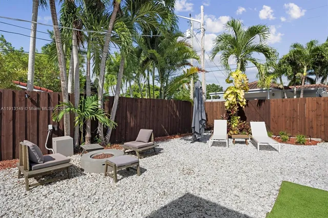 a view of a backyard with a table and chairs