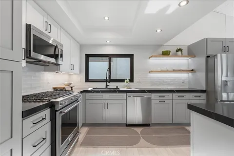 a kitchen with stainless steel appliances kitchen island granite countertop a sink and a stove