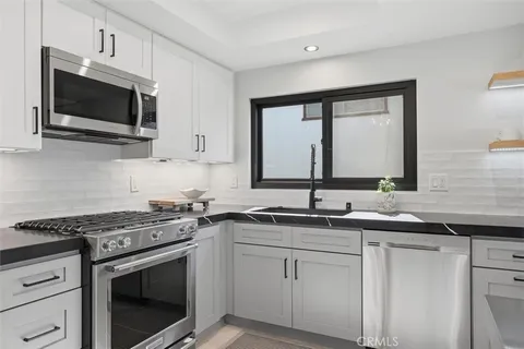 a kitchen with stainless steel appliances a sink stove top oven and microwave