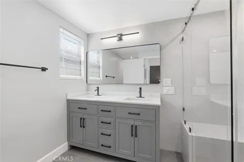 a bathroom with a granite countertop sink mirror and a bathtub