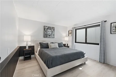 a bedroom with a bed and a painting on the wall