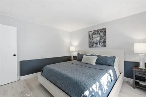a bedroom with a bed and a lamp on dresser