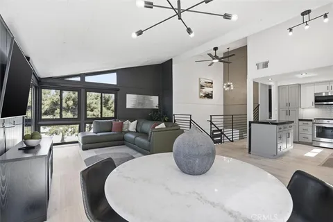 a living room with furniture a large window and flat screen tv