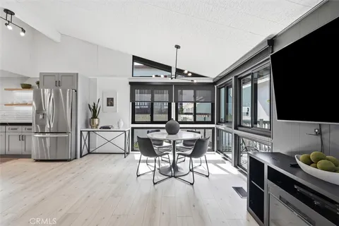 a kitchen with stainless steel appliances kitchen island granite countertop a table chairs and a refrigerator