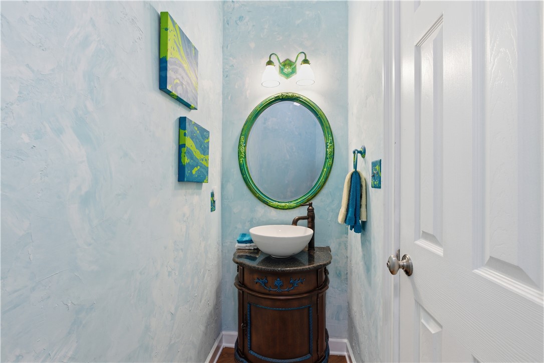 501 Capri Point Lavonia, GA 30553 - Photo 34 of 50 This chic powder room features a vessel sink, a decorative mirror, and a wall-mounted light fixture.