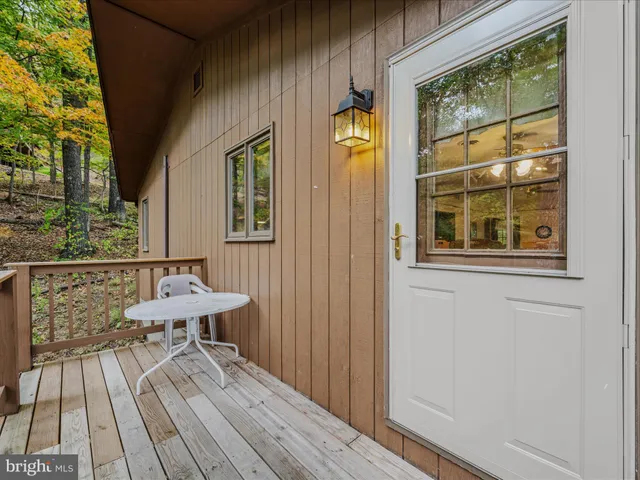 a view of a balcony with chairs and wooden floor