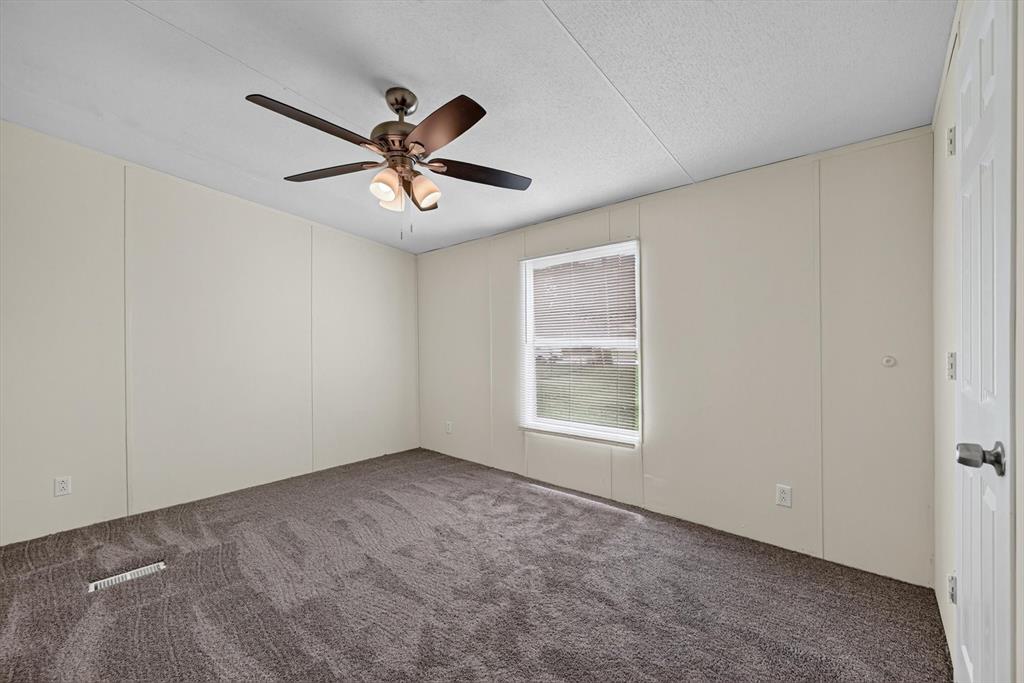 13405 Wheat Road Venus, TX 76084 - Photo 21 of 32 Interior room featuring textured carpeting, a ceiling fan with integrated lighting, and a single window