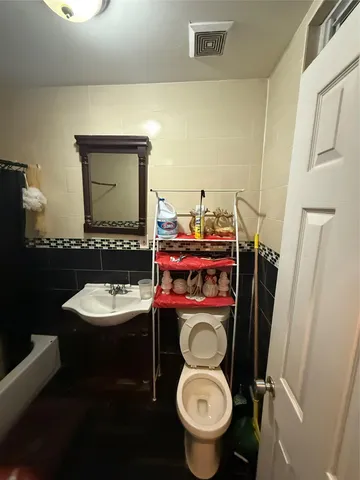 a bathroom with a toilet sink and mirror
