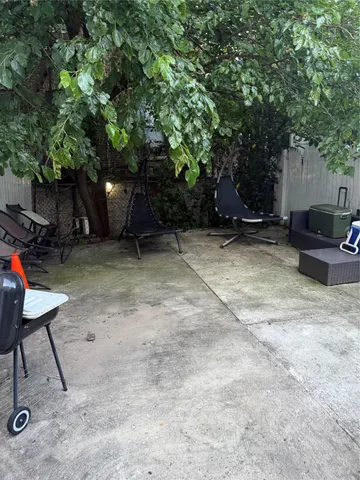 a view of a backyard with furniture and a tree
