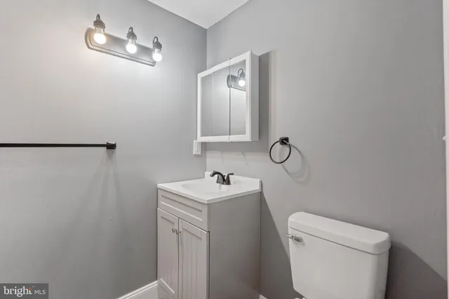 a bathroom with a sink toilet and a mirror
