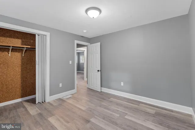 an empty room with wooden floor and closet