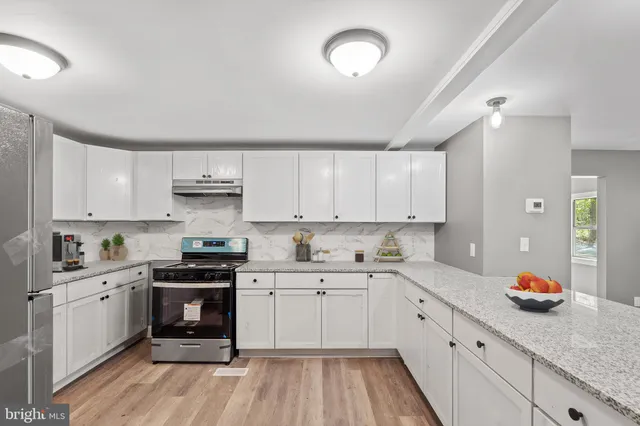 a kitchen with granite countertop white cabinets and white appliances