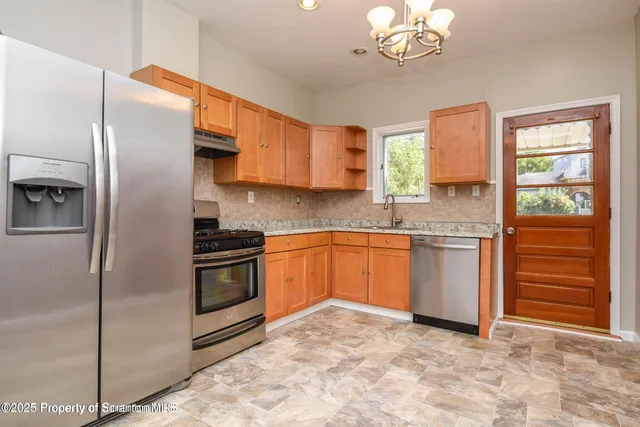 a kitchen with granite countertop a sink stainless steel appliances and cabinets