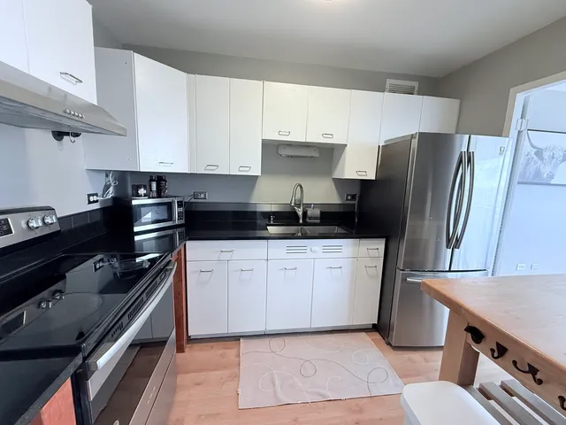 a kitchen with stainless steel appliances granite countertop a refrigerator and a stove