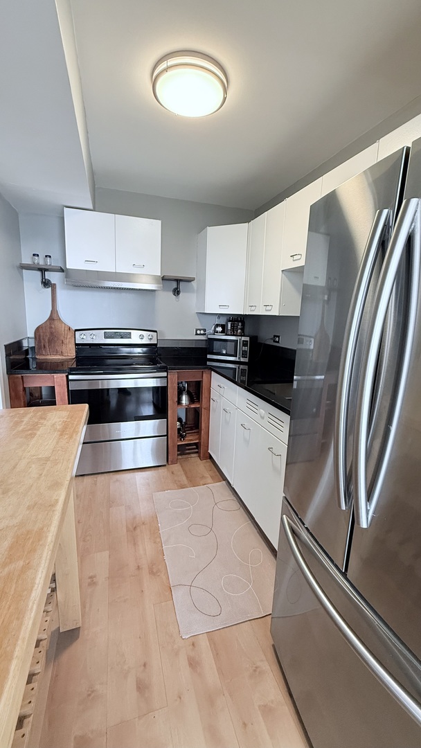 6301 North Sheridan Road, Unit 19V Chicago, IL 60660 - Photo 4 of 16 a kitchen with stainless steel appliances granite countertop a refrigerator and a stove
